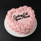 Pink frosted cake with 'Custom Cut Your Phrase' text on a black background